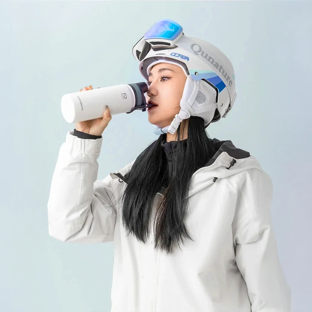 femme qui boit dans une gourde en acier inoxydable isotherme